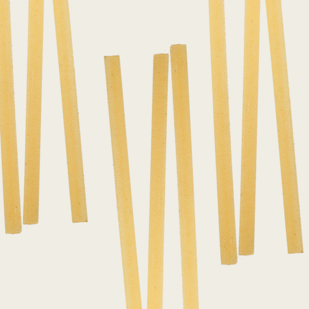 Yellow pasta sticks on a light beige background