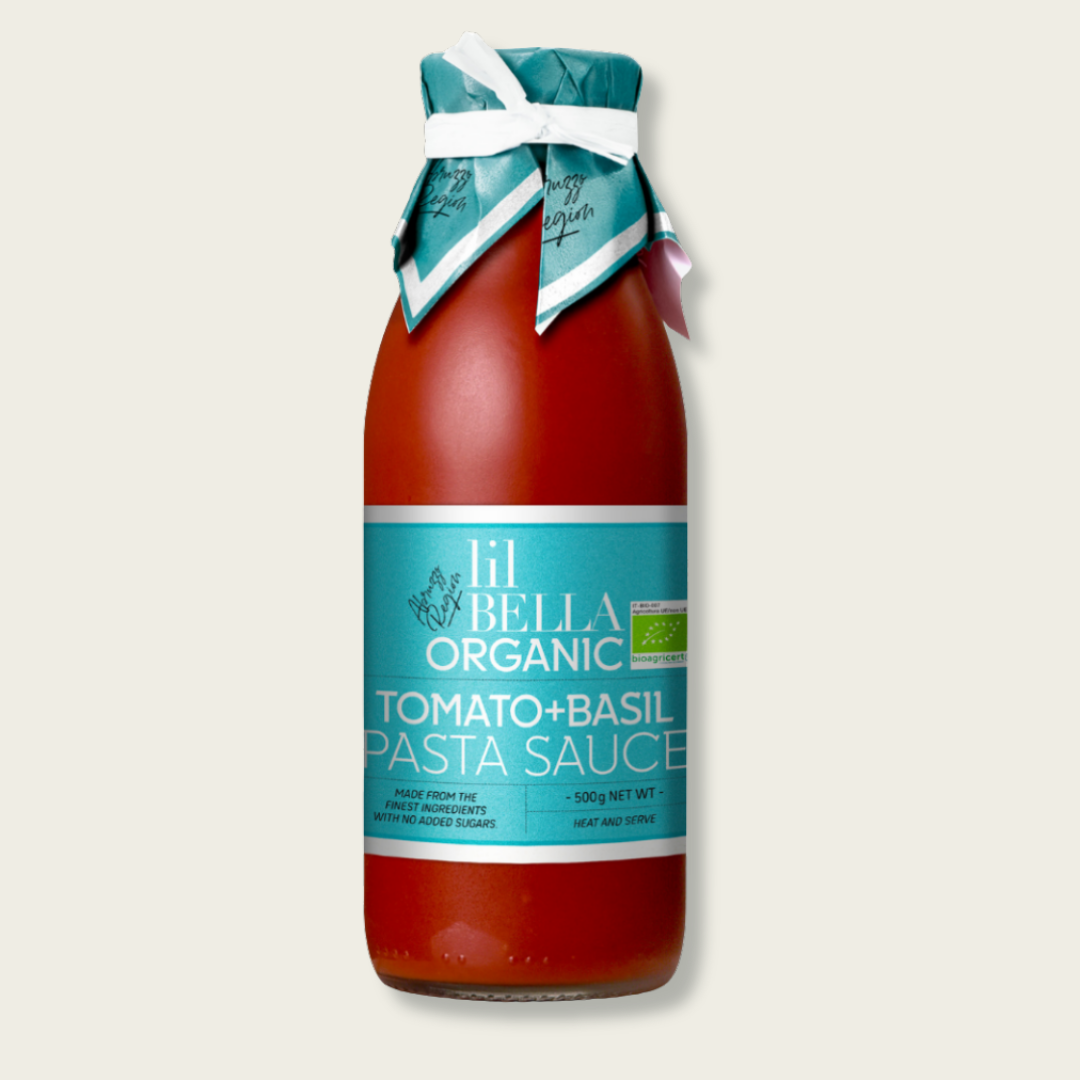 Bottle of Lil Bella Organic Tomato Basil Pasta Sauce with a blue label on a light beige background