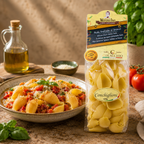 Packaged pasta with a bowl of pasta dish on a wooden table.