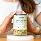 Person holding a jar of Greek Organic Olympus Tea by Myst on a white background