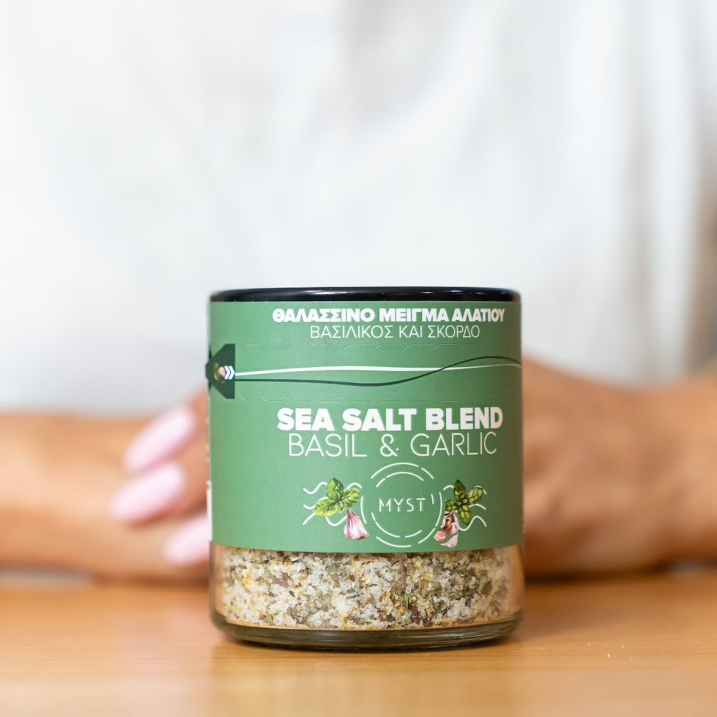 Jar of sea salt blend with basil and garlic on a wooden surface