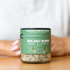 Jar of sea salt blend with basil and garlic on a wooden surface