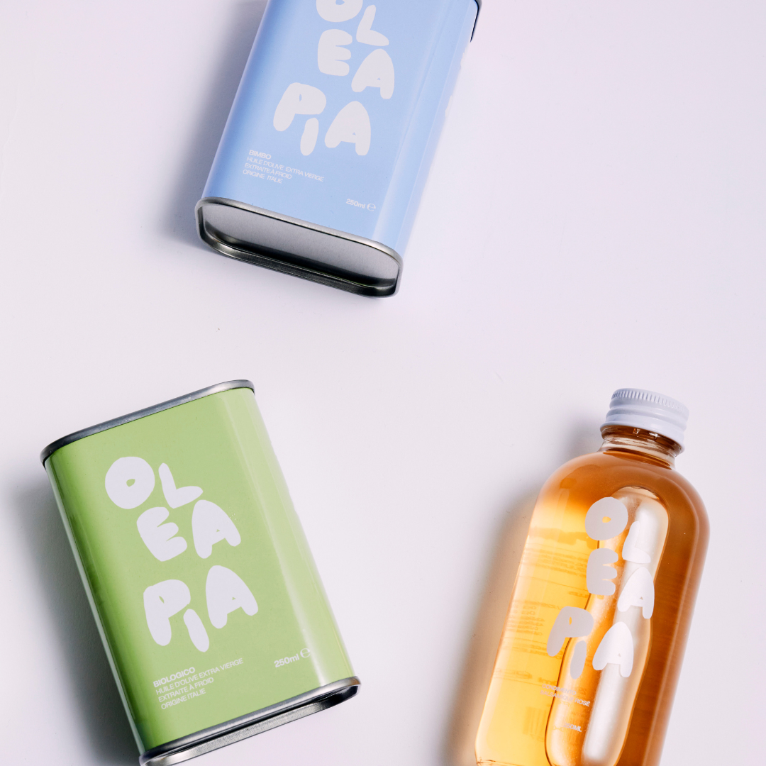Three 'Olea Ria' products including a can, a bottle, and a can on a light gray background.