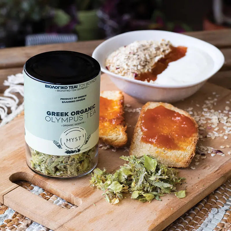 Jar of Greek Organic Olympus Tea on a wooden board with bread and spread