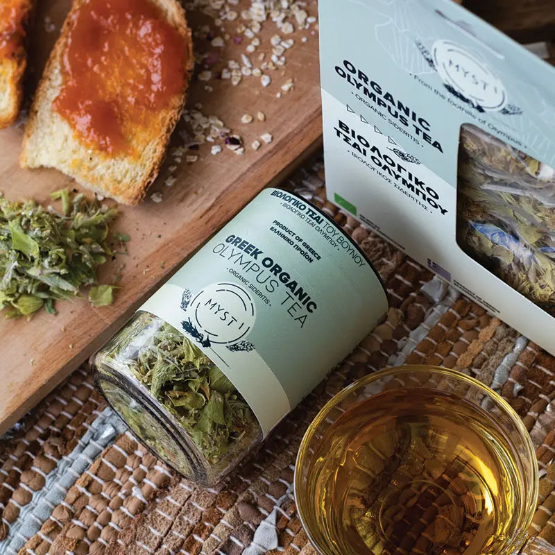 Myst Organic Olympus Tea packaging with a glass of tea and toast on a wooden board.
