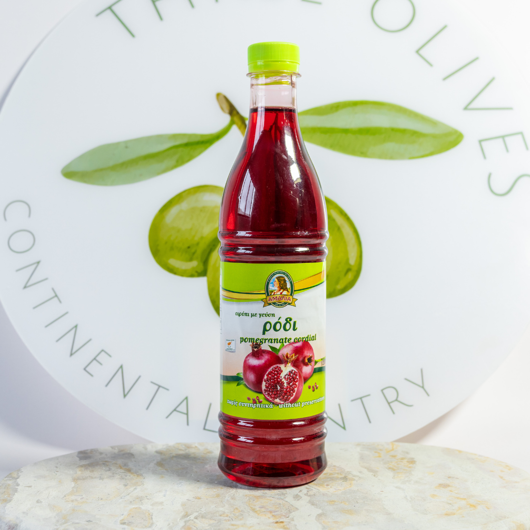 Bottle of pomegranate juice with a green cap on a white background with text.