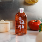 Bottle of Olea Pia on a kitchen counter with pumpkins in the background